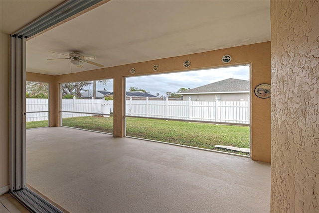 unfurnished sunroom with ceiling fan