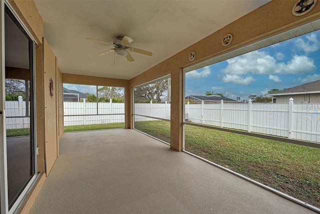 unfurnished sunroom with ceiling fan