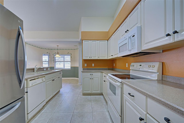 kitchen with white cabinetry, light tile patterned floors, hanging light fixtures, sink, and white appliances