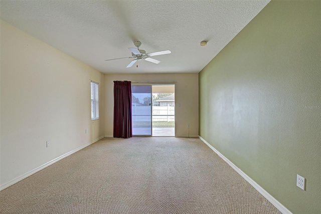 carpeted empty room featuring a textured ceiling and ceiling fan