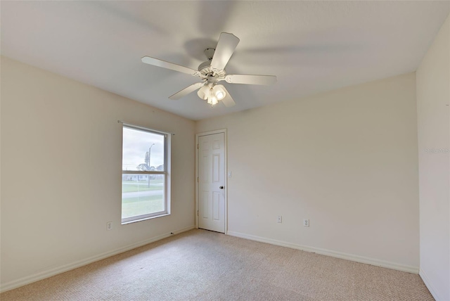 carpeted spare room with ceiling fan