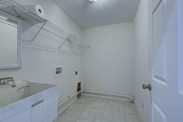 laundry room featuring hookup for a washing machine, electric dryer hookup, a textured ceiling, and light tile patterned floors