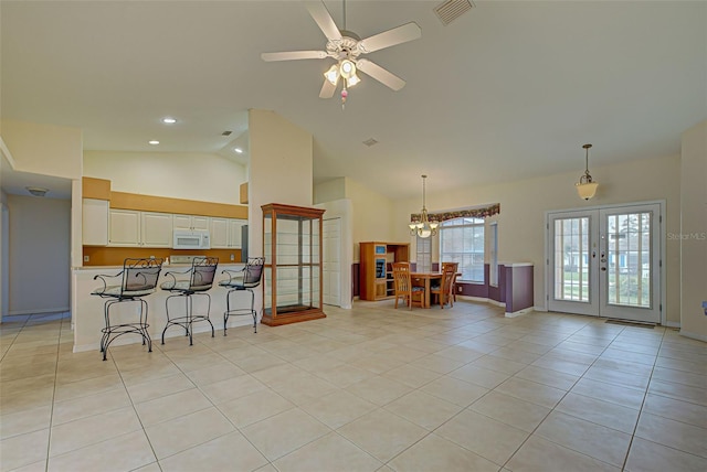 kitchen with french doors, white cabinets, hanging light fixtures, light tile patterned floors, and a breakfast bar