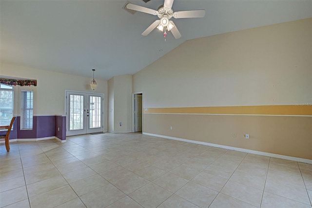 tiled empty room featuring vaulted ceiling, ceiling fan, and french doors