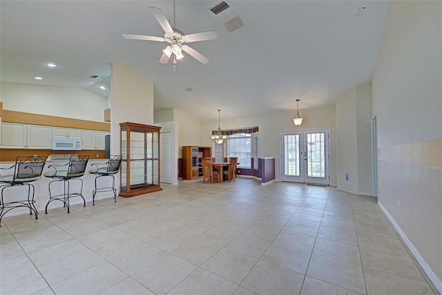 living room with ceiling fan with notable chandelier, high vaulted ceiling, light tile patterned floors, and french doors