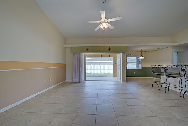 unfurnished room with lofted ceiling, light tile patterned floors, and ceiling fan