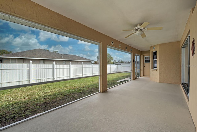 unfurnished sunroom with ceiling fan