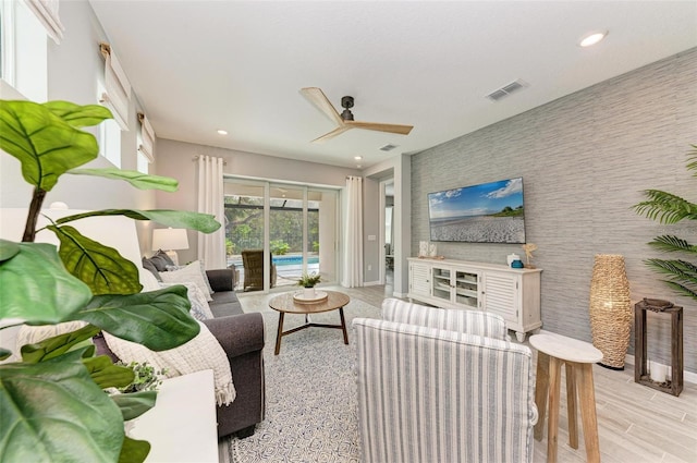 living room with light wood-type flooring and ceiling fan