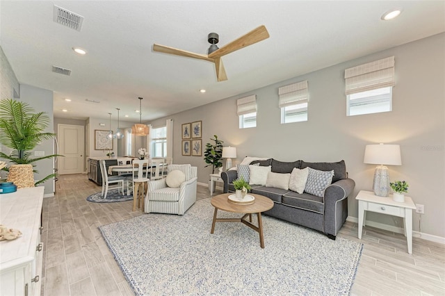 living room with light hardwood / wood-style floors and ceiling fan