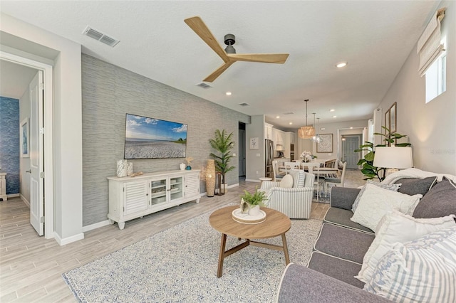 living room with light hardwood / wood-style floors and ceiling fan