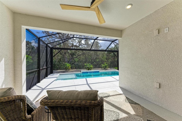 view of swimming pool with a patio, ceiling fan, and a lanai