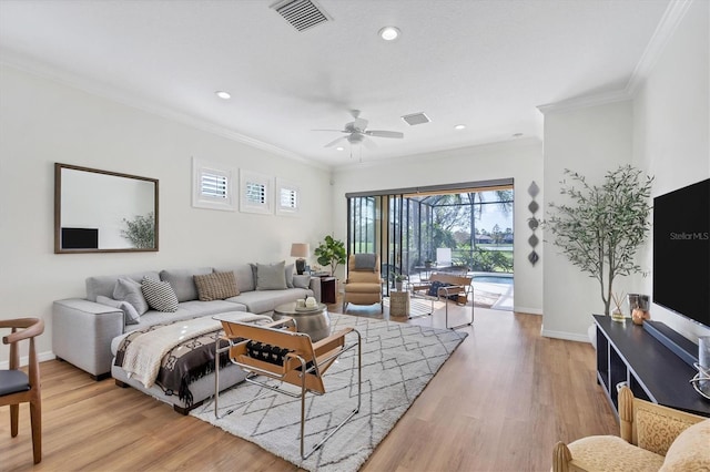 living room featuring light hardwood / wood-style flooring, ceiling fan, and crown molding