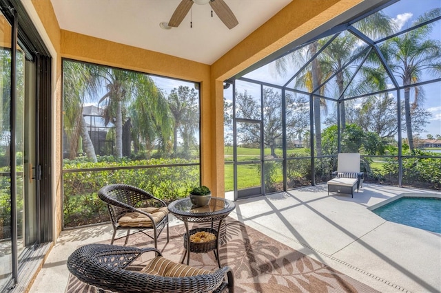 sunroom / solarium with a healthy amount of sunlight, ceiling fan, and a pool