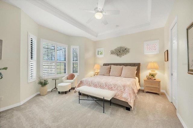 carpeted bedroom featuring a tray ceiling, a ceiling fan, and baseboards