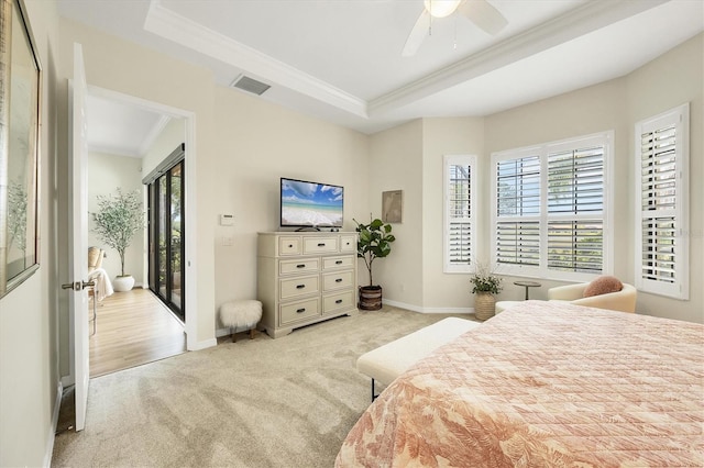 bedroom with visible vents, a raised ceiling, ornamental molding, and light colored carpet