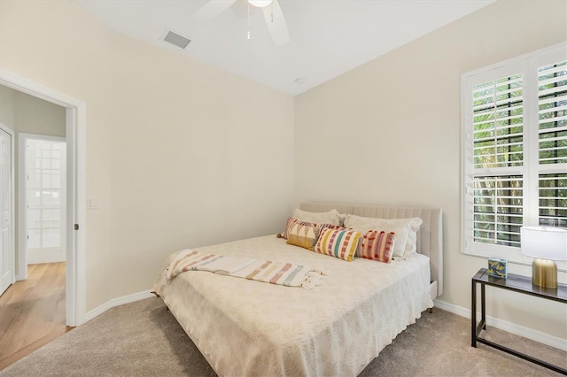 carpeted bedroom with baseboards, a ceiling fan, and visible vents