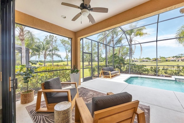 outdoor pool with an outdoor living space, a patio area, glass enclosure, and ceiling fan