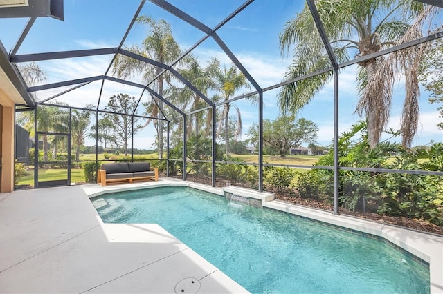 outdoor pool featuring glass enclosure and a patio