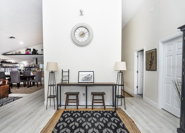 interior space featuring high vaulted ceiling and light wood-type flooring