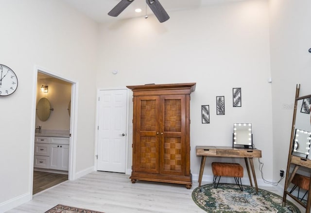 6317 Werner Ave, New Port Richey, FL 34652 - bedroom with light wood-style floors, baseboards, a towering ceiling, connected bathroom, and an office area