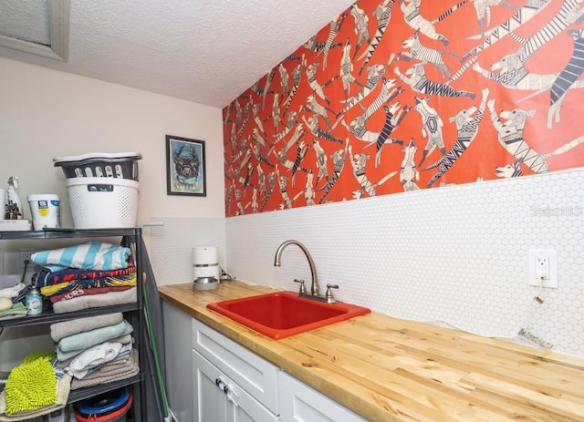 6317 Werner Ave, New Port Richey, FL 34652 - kitchen featuring a sink, butcher block countertops, a textured ceiling, and backsplash