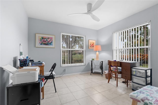 office area with a ceiling fan, a wealth of natural light, baseboards, and light tile patterned floors