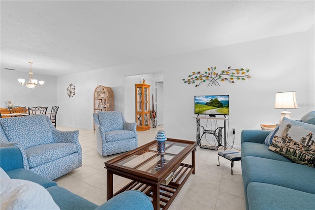 living area featuring an inviting chandelier, a textured ceiling, and light tile patterned flooring