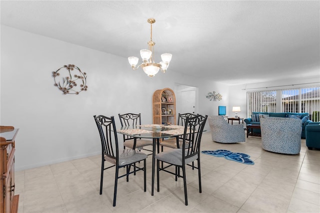 dining room featuring a notable chandelier and baseboards