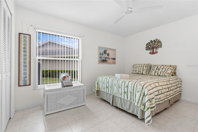 bedroom featuring a closet, tile patterned flooring, a ceiling fan, and baseboards