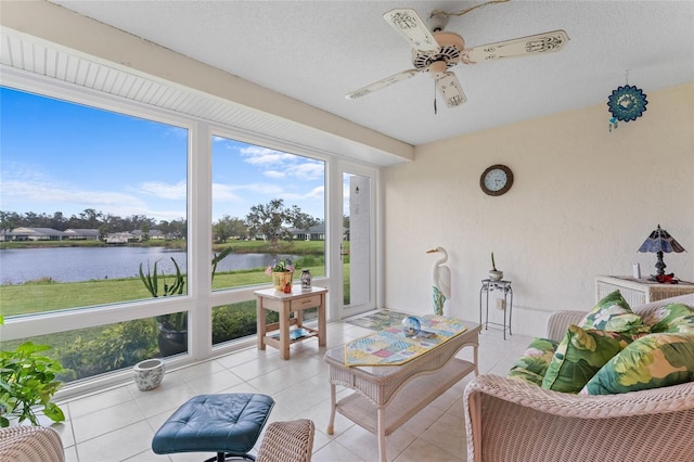 sunroom featuring ceiling fan and a water view