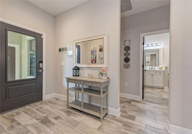 entryway with sink and light wood-type flooring