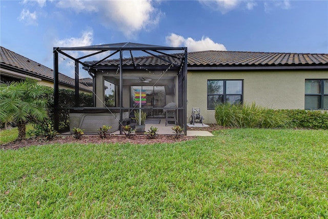 back of property featuring a patio, a yard, and glass enclosure