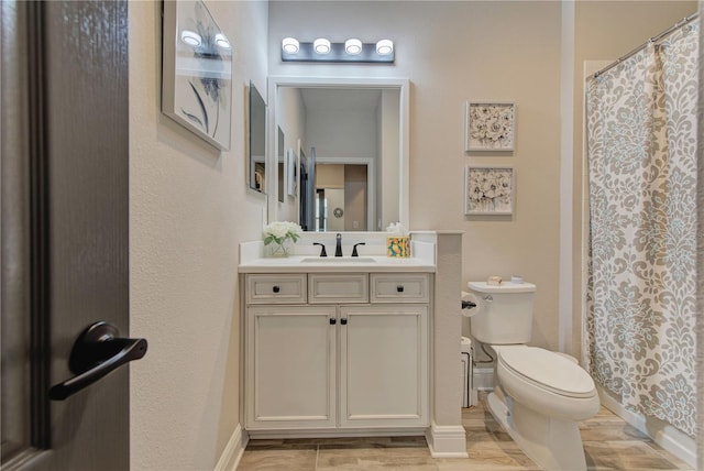 bathroom featuring toilet, vanity, and a shower with shower curtain