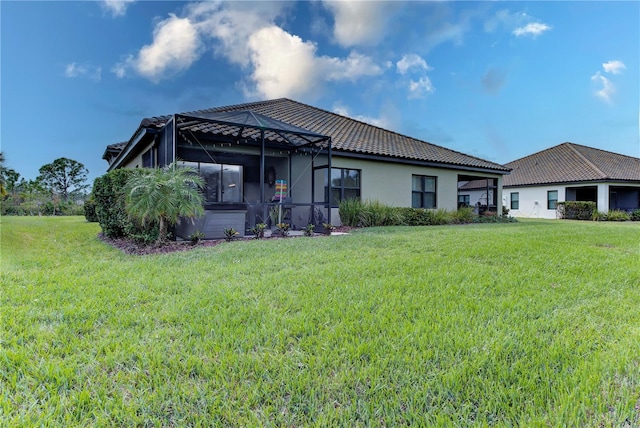 back of house featuring a lawn and a lanai