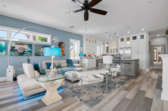 living room featuring light hardwood / wood-style floors and ceiling fan