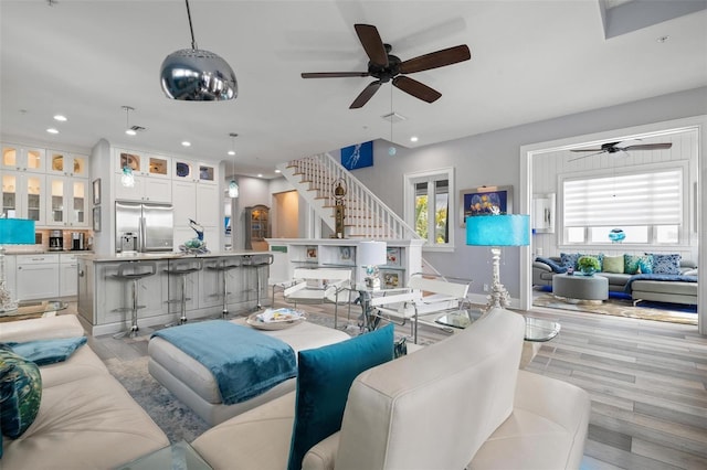 living room with light hardwood / wood-style flooring and ceiling fan