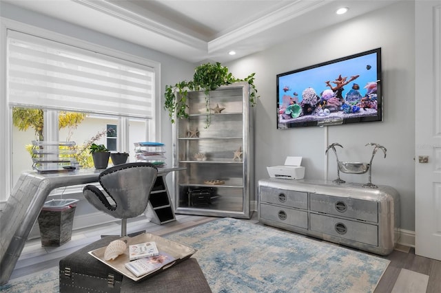 office space featuring ornamental molding, light hardwood / wood-style flooring, and a raised ceiling