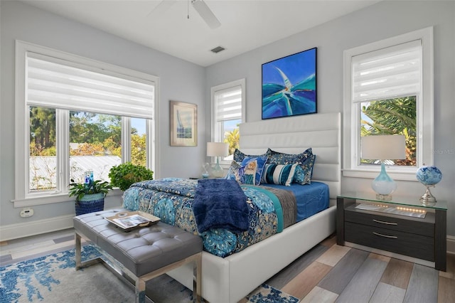 bedroom featuring light hardwood / wood-style floors, multiple windows, and ceiling fan