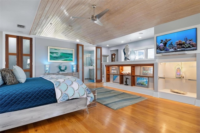 bedroom with wooden ceiling, connected bathroom, wood-type flooring, and ceiling fan