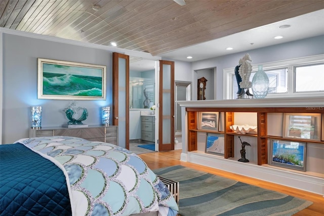 bedroom with light hardwood / wood-style floors, wood ceiling, ensuite bath, and crown molding