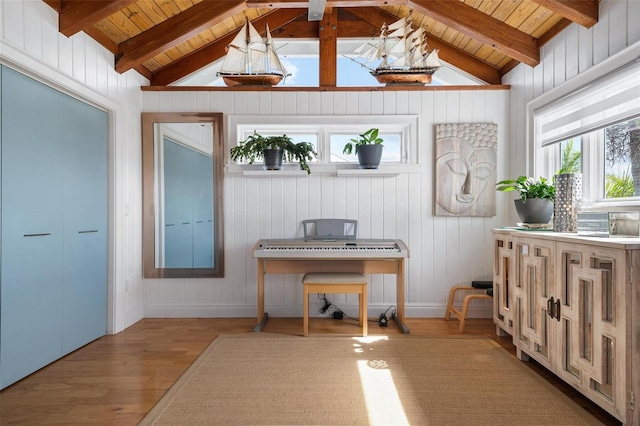 interior space with vaulted ceiling with beams, light hardwood / wood-style flooring, a healthy amount of sunlight, and wood ceiling