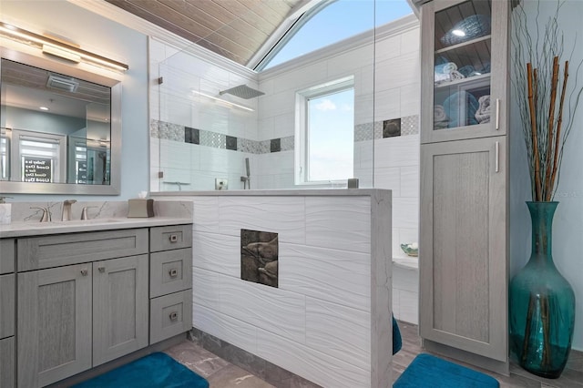 bathroom with vanity, walk in shower, vaulted ceiling, and tile walls