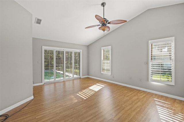 spare room with vaulted ceiling, light hardwood / wood-style flooring, ceiling fan, and a healthy amount of sunlight