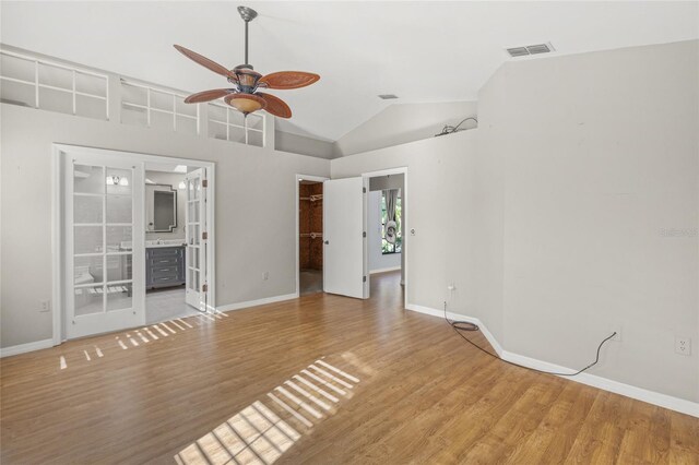 spare room featuring ceiling fan, high vaulted ceiling, and wood-type flooring