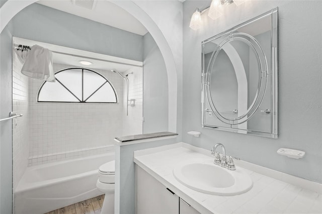 full bathroom featuring vanity, hardwood / wood-style flooring, toilet, and tiled shower / bath