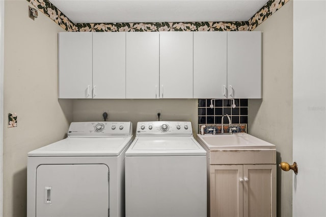 washroom featuring cabinets, washer and dryer, and sink