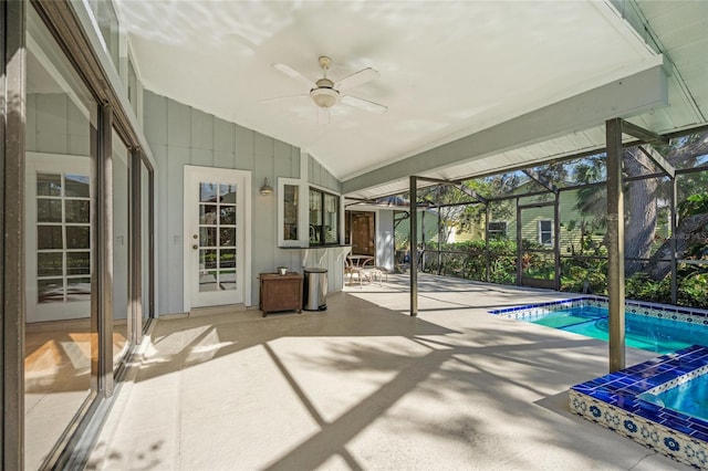 view of swimming pool with glass enclosure, ceiling fan, and a patio