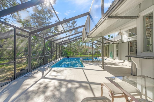 view of swimming pool with a patio, ceiling fan, and a lanai