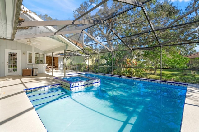 view of swimming pool featuring an in ground hot tub, glass enclosure, ceiling fan, and a patio area