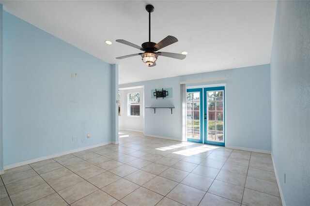 tiled spare room with vaulted ceiling, ceiling fan, a healthy amount of sunlight, and french doors